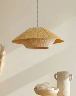 Side angle view of Rivora pendant light showing textured natural raffia weave in minimalist interior setting