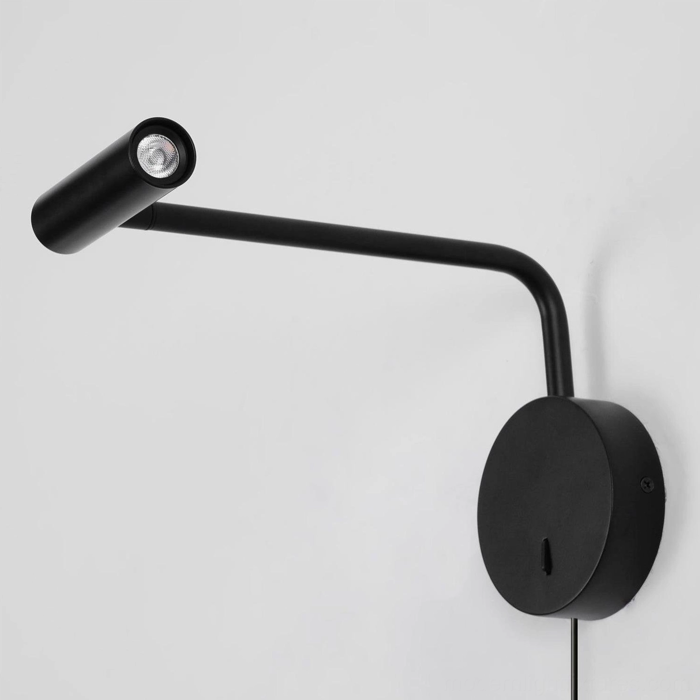 Rizo plug-in wall lamp wide bedroom view showing soft warm lighting ambience