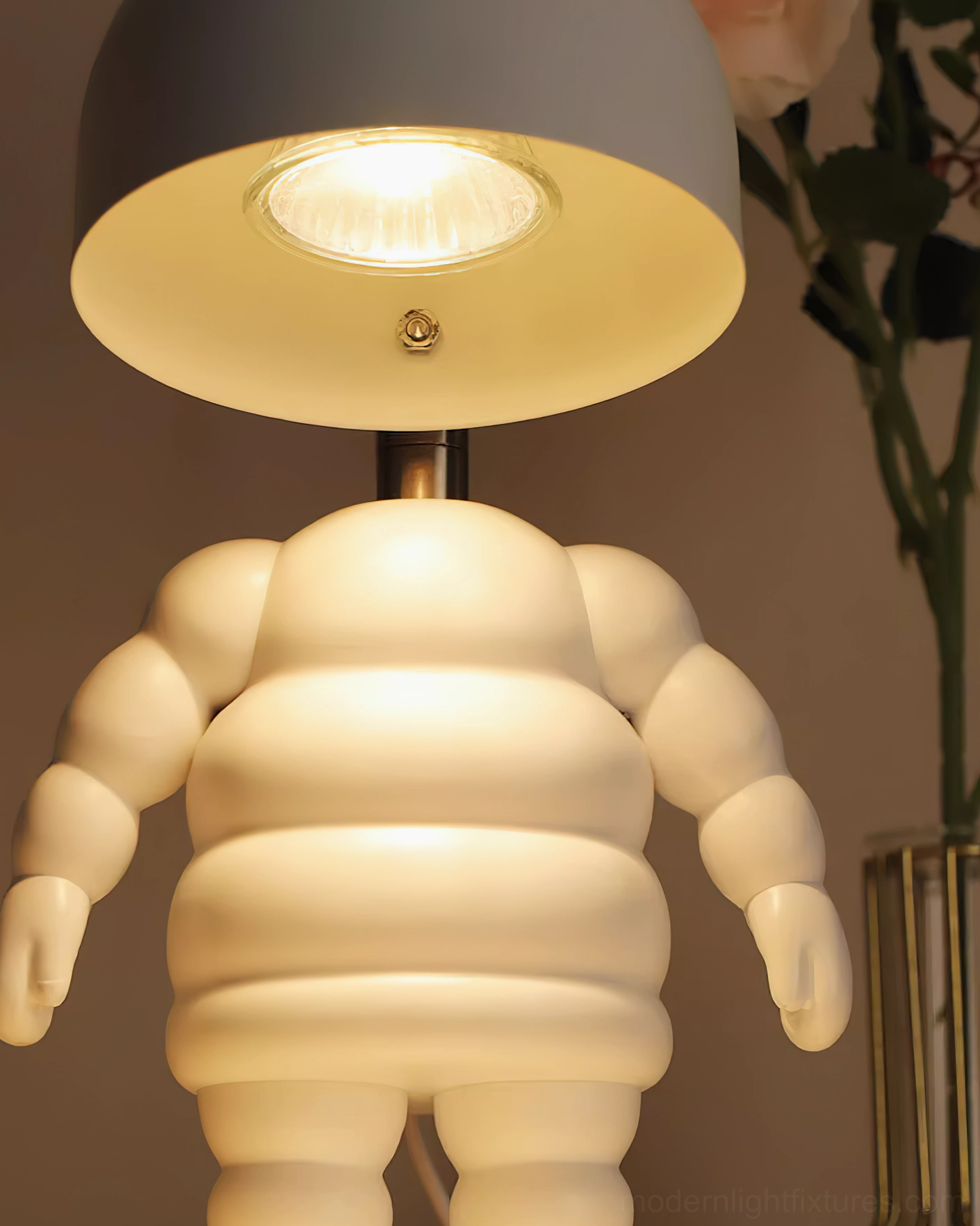 Extreme close-up detail shot of robot candle warmer lamp showing matte white ribbed torso and warm internal lighting