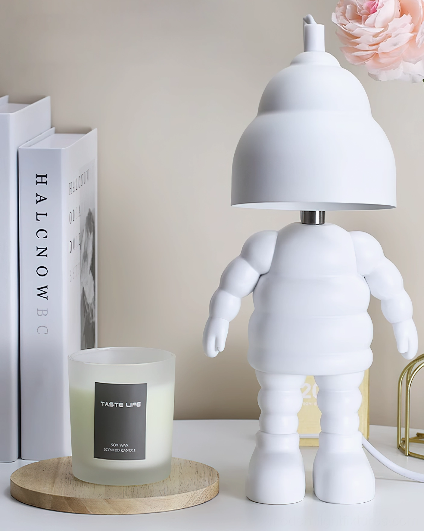 Minimalist robot candle warmer lamp on clean desktop with books and scented candle on wooden coaster