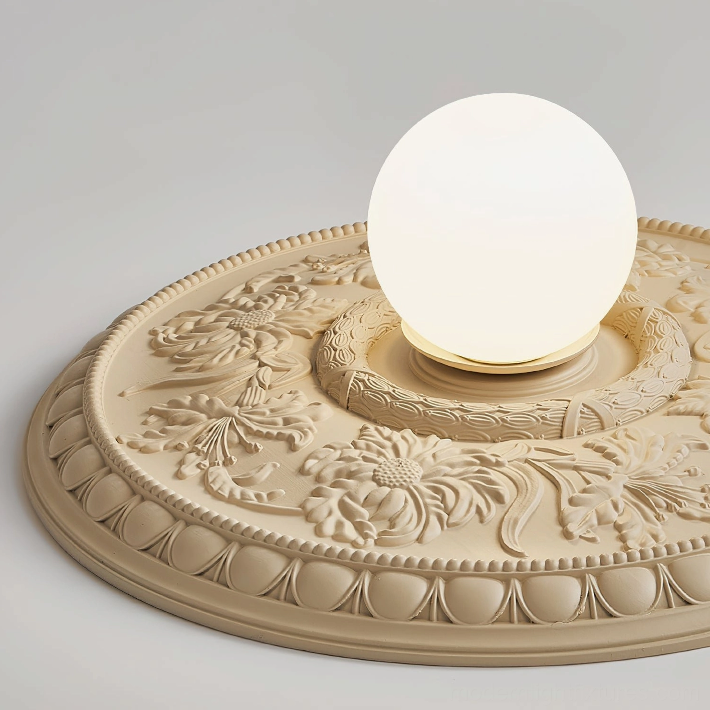 Full front view of Rochelle carved ceiling light with beige resin base and frosted globe bulb on studio background