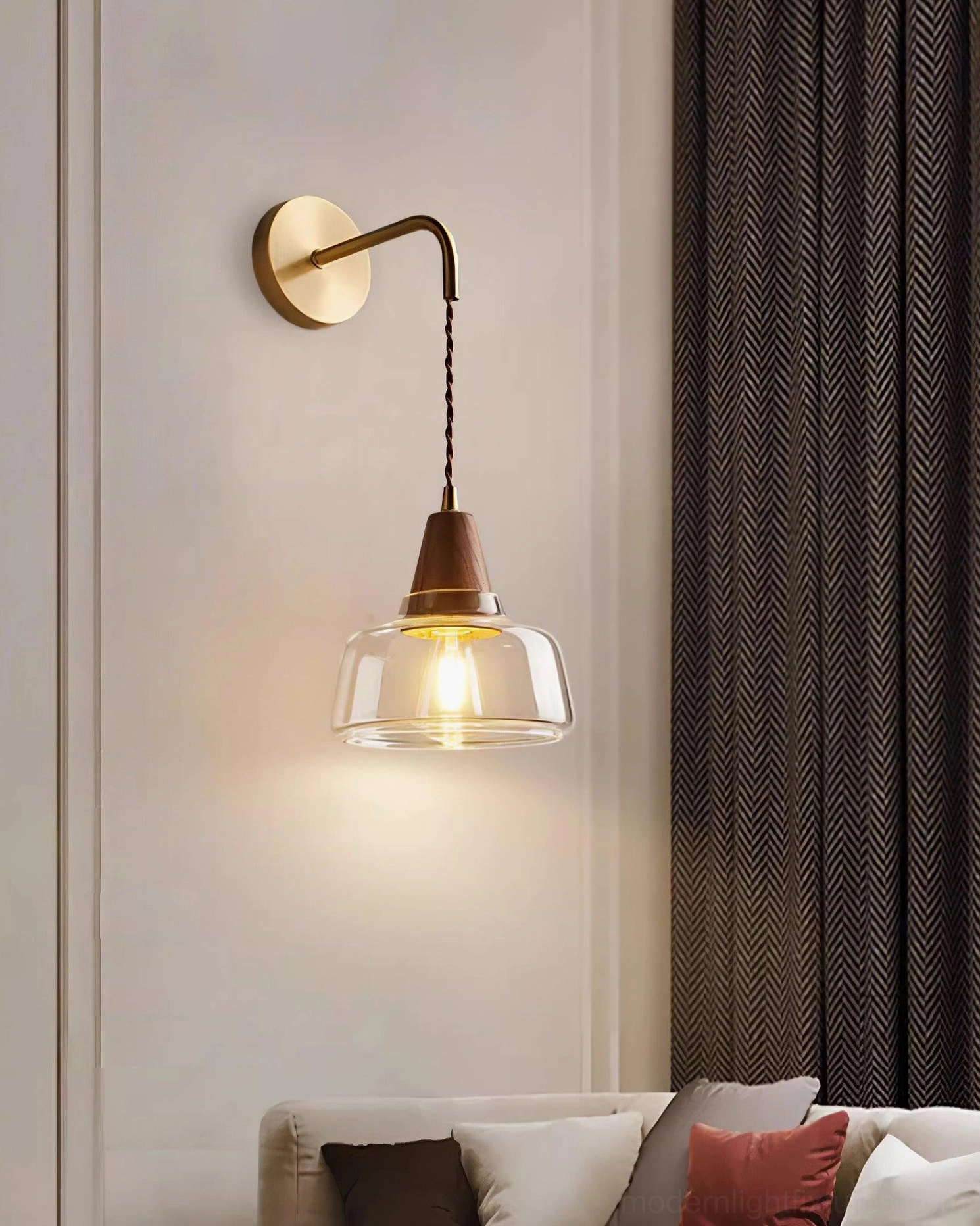 Pair of matching plug-in wall sconces flanking sofa - brass and wood glass fixtures in residential living room