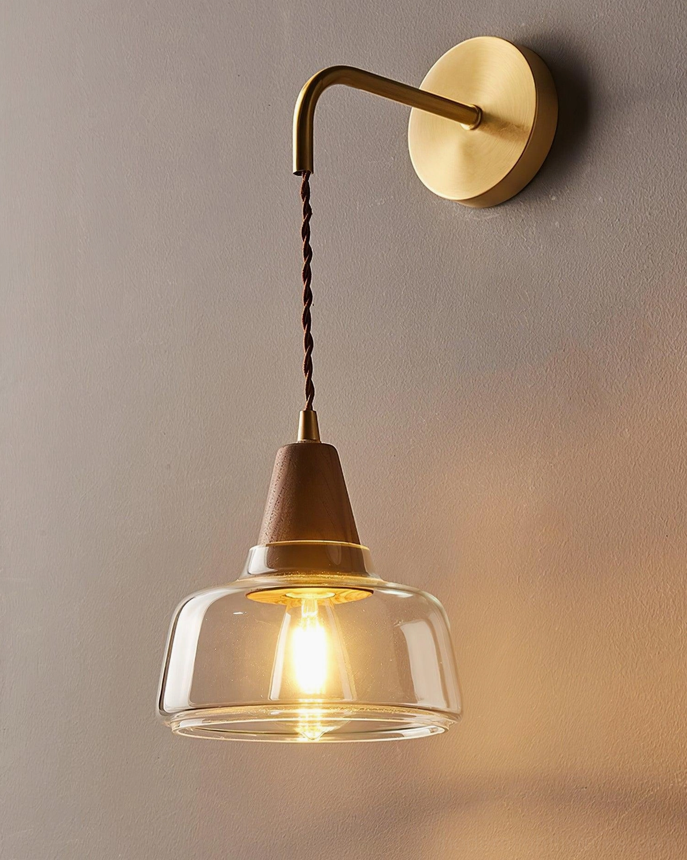 Rockford wall sconce side profile showing curved brass arm and twisted fabric cord - minimalist Nordic lighting