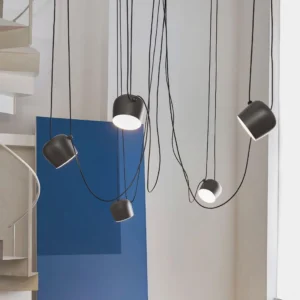 Multi-head Ronan pendant lights installed in modern stairwell, industrial minimalist aesthetic with exposed black cords