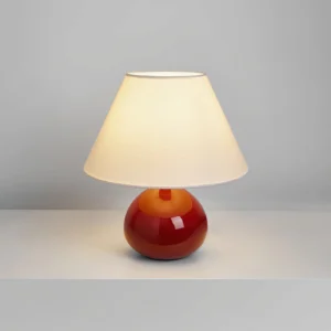 Ronda retro table lamp with burgundy ceramic base emitting warm light, studio lighting on grey surface