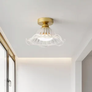 Rosa brass and glass ceiling fixture mounted on white wall in minimalist entryway, eye-level perspective