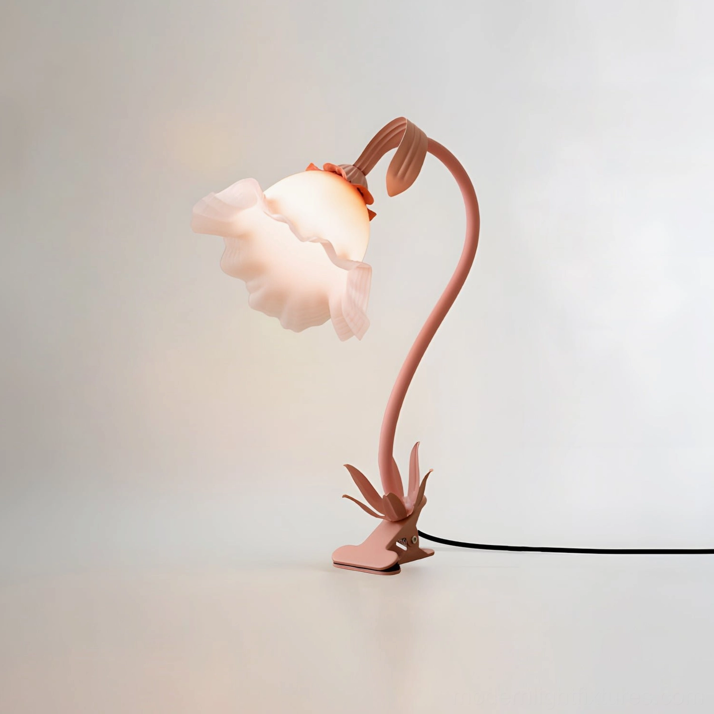 Matte pink Rosalie floral desk lamp with exposed power cord and botanical metal stand on studio background