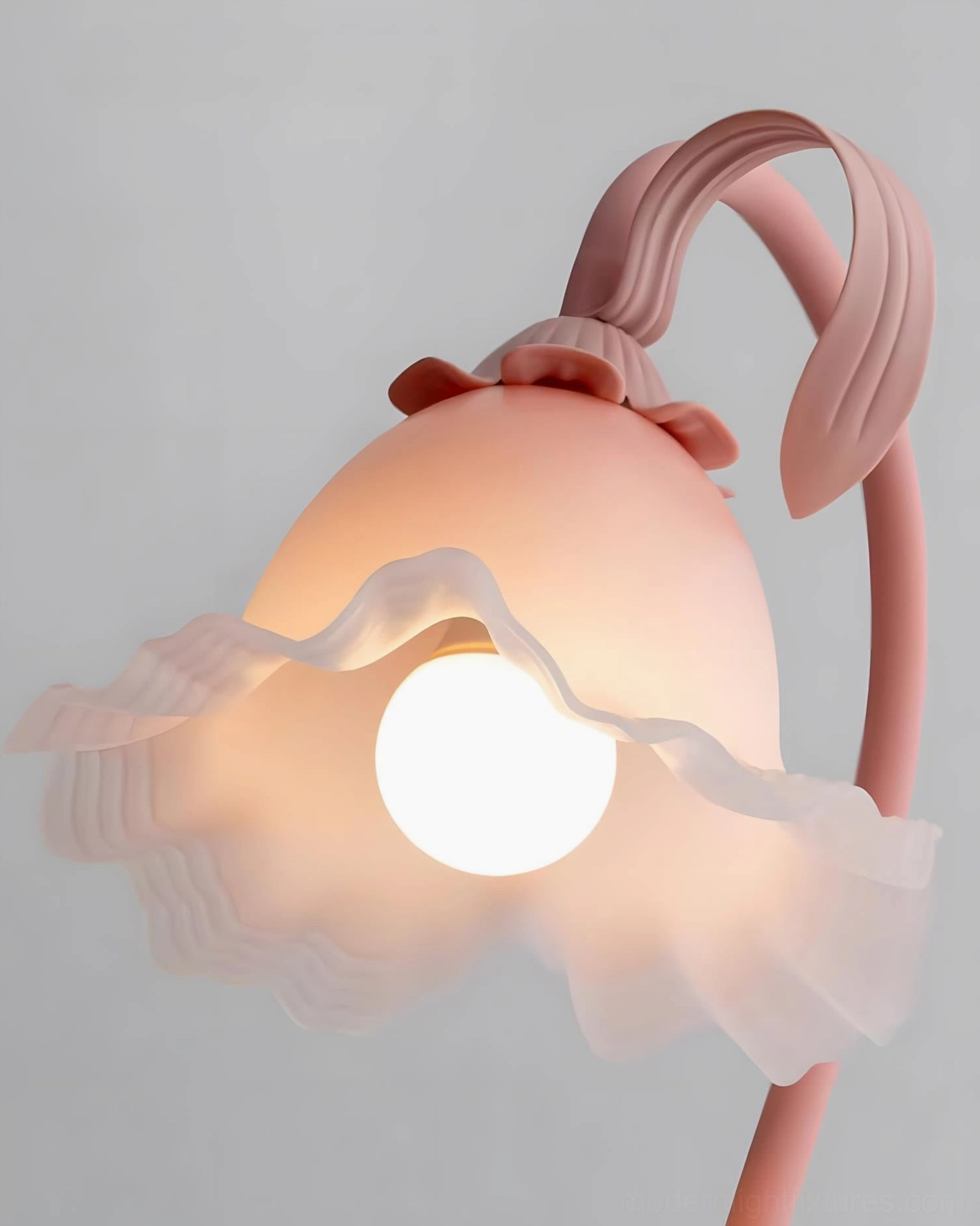 Close-up detail of matte pink Rosalie lamp with ruffled frosted glass shade and visible globe bulb