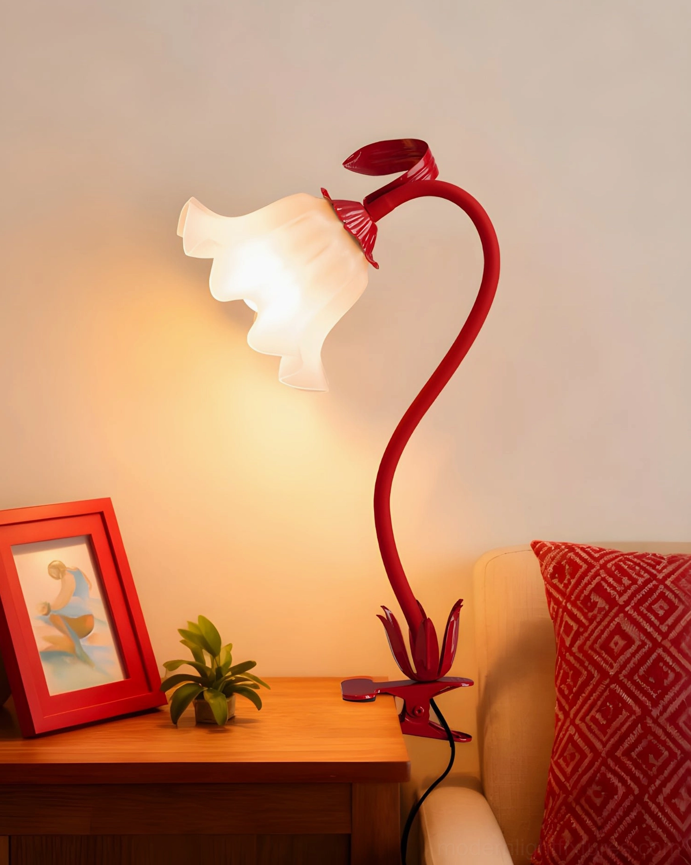 Deep red burgundy Rosalie floral clip lamp on living room side table with framed art and potted plant