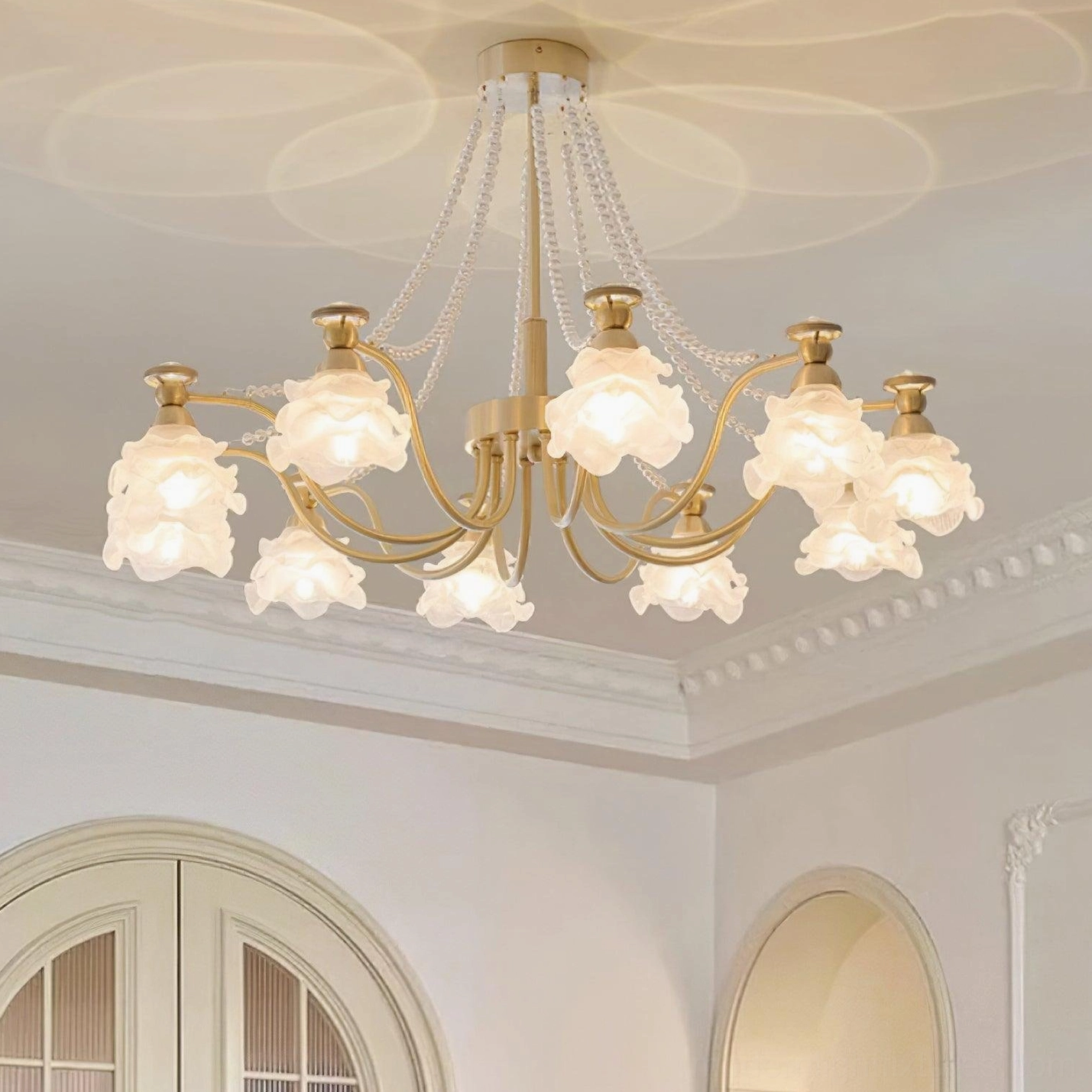 Rose glass chandelier illuminated showing warm light through frosted glass petals