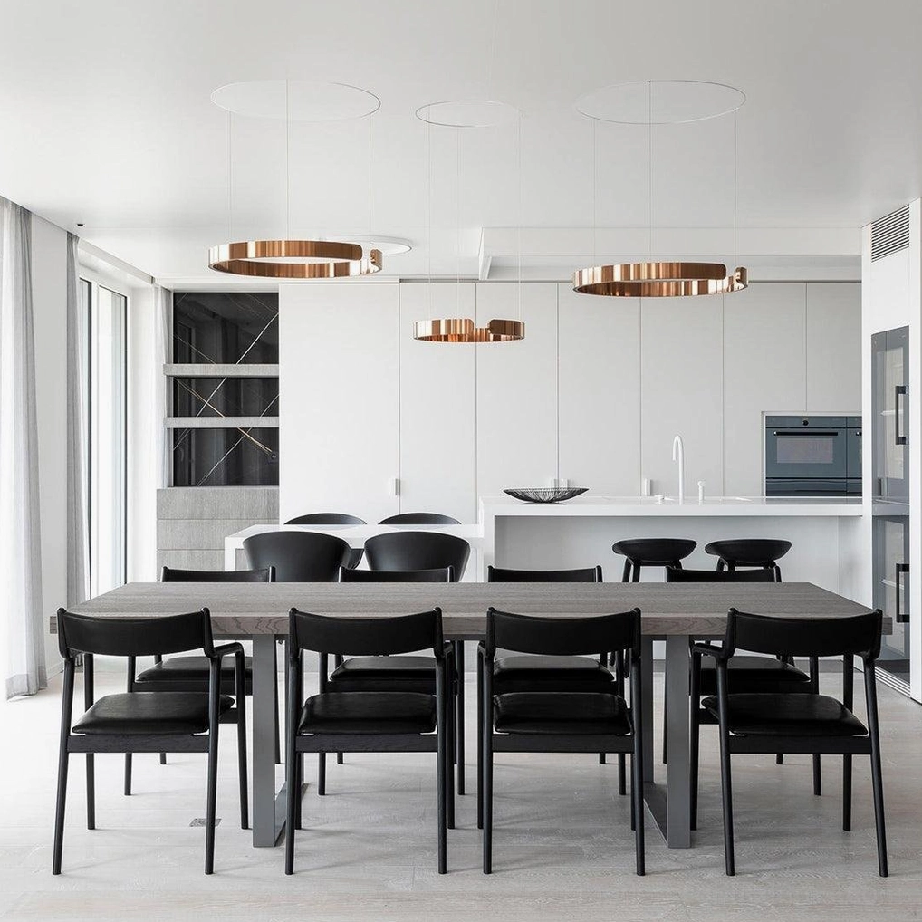 Multi-unit rose gold halo ring pendant lights in contemporary large dining kitchen with white cabinet backdrop