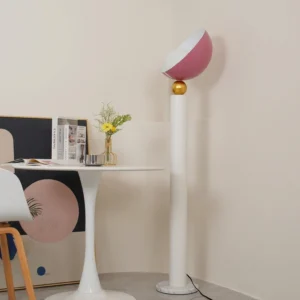 Rose red half-sphere floor lamp in contemporary dining nook with small round table, minimalist interior styling