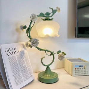Modern floral desk lamp lit on home office desk with magazine and retro radio decoration