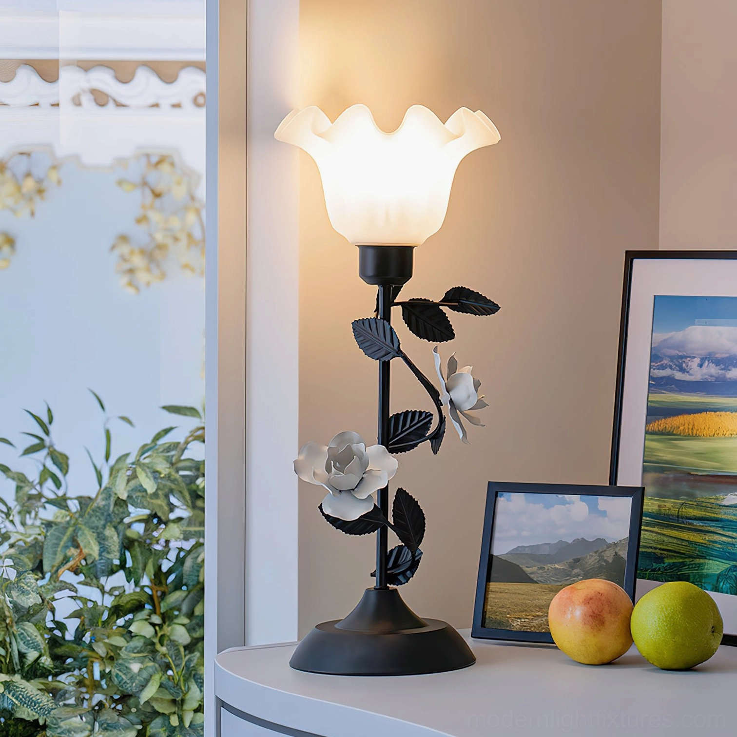 Roselith rose-shaped decorative table lamp side view on console table with framed artwork and fruit bowl, black metal frame white frosted glass