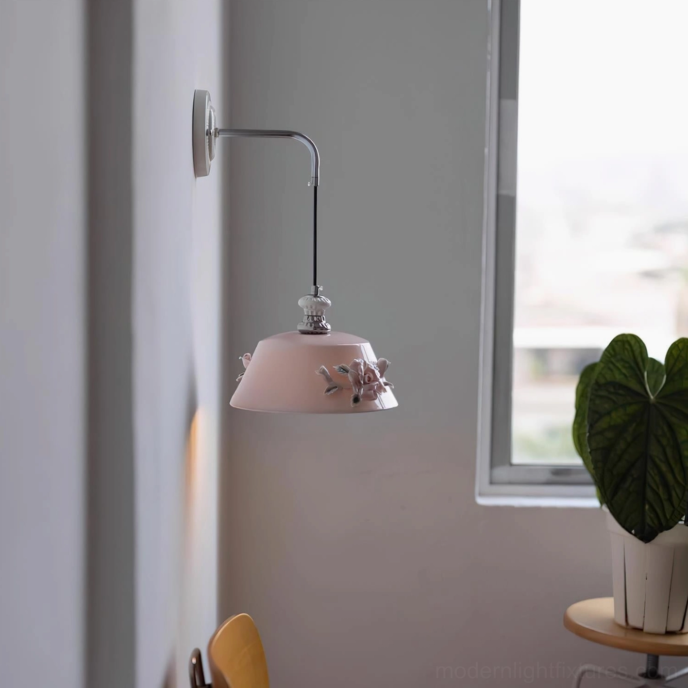 Ceramic wall lamp Roselune with pink flower-decorated shade and curved silver metal arm in Nordic minimalist home interior