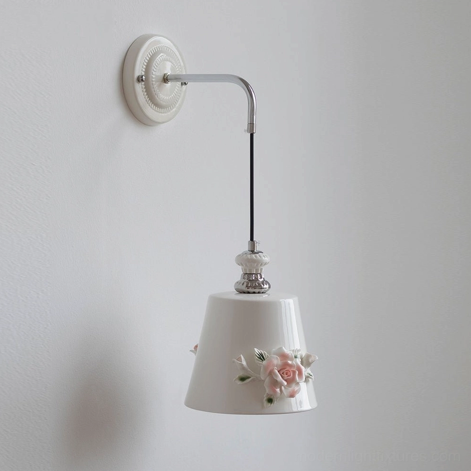 White ceramic Roselune wall sconce with three-dimensional pink floral decor shade and polished chrome metal arm, studio photography