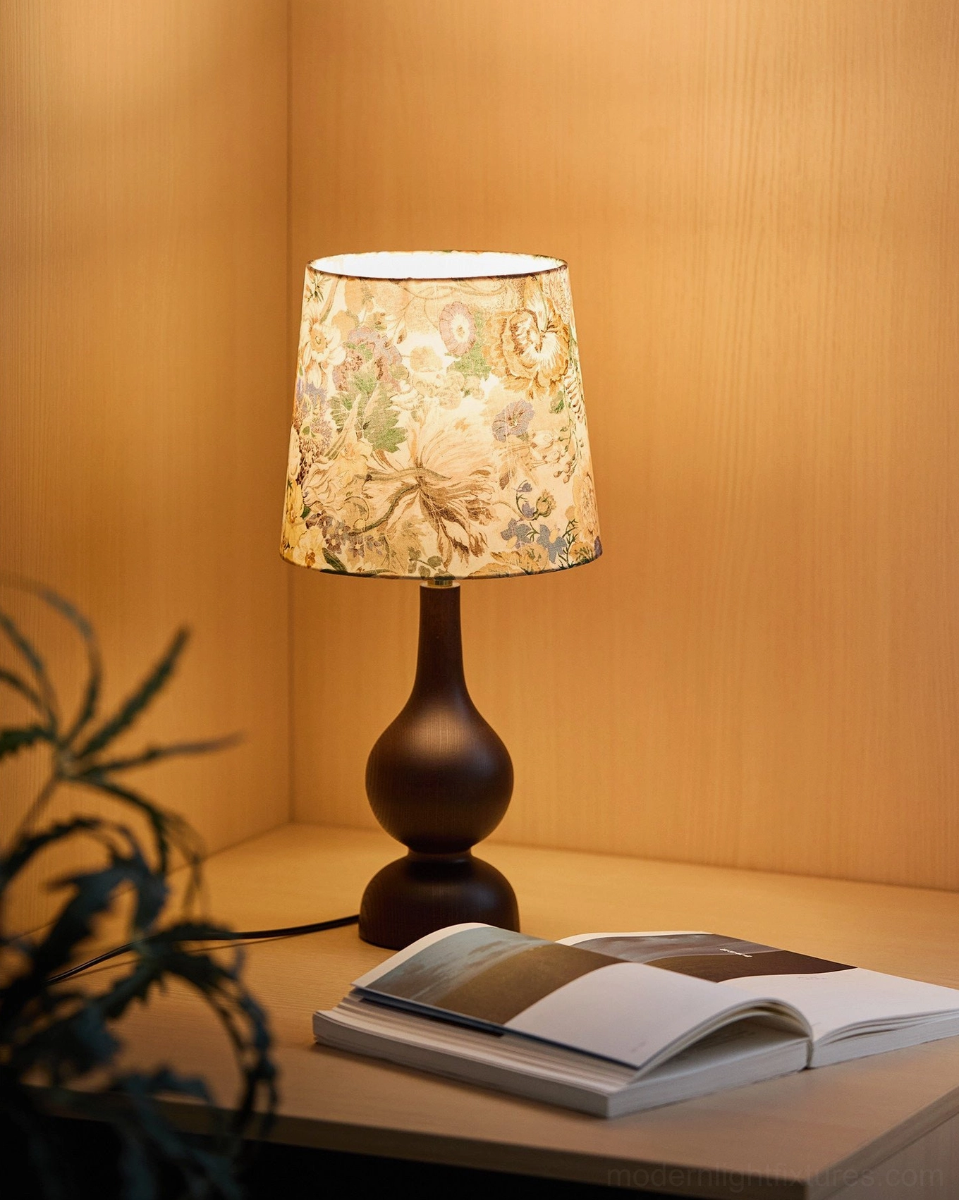 Mid-century table lamp on bedroom nightstand with warm 3000K ambient lighting beside open book