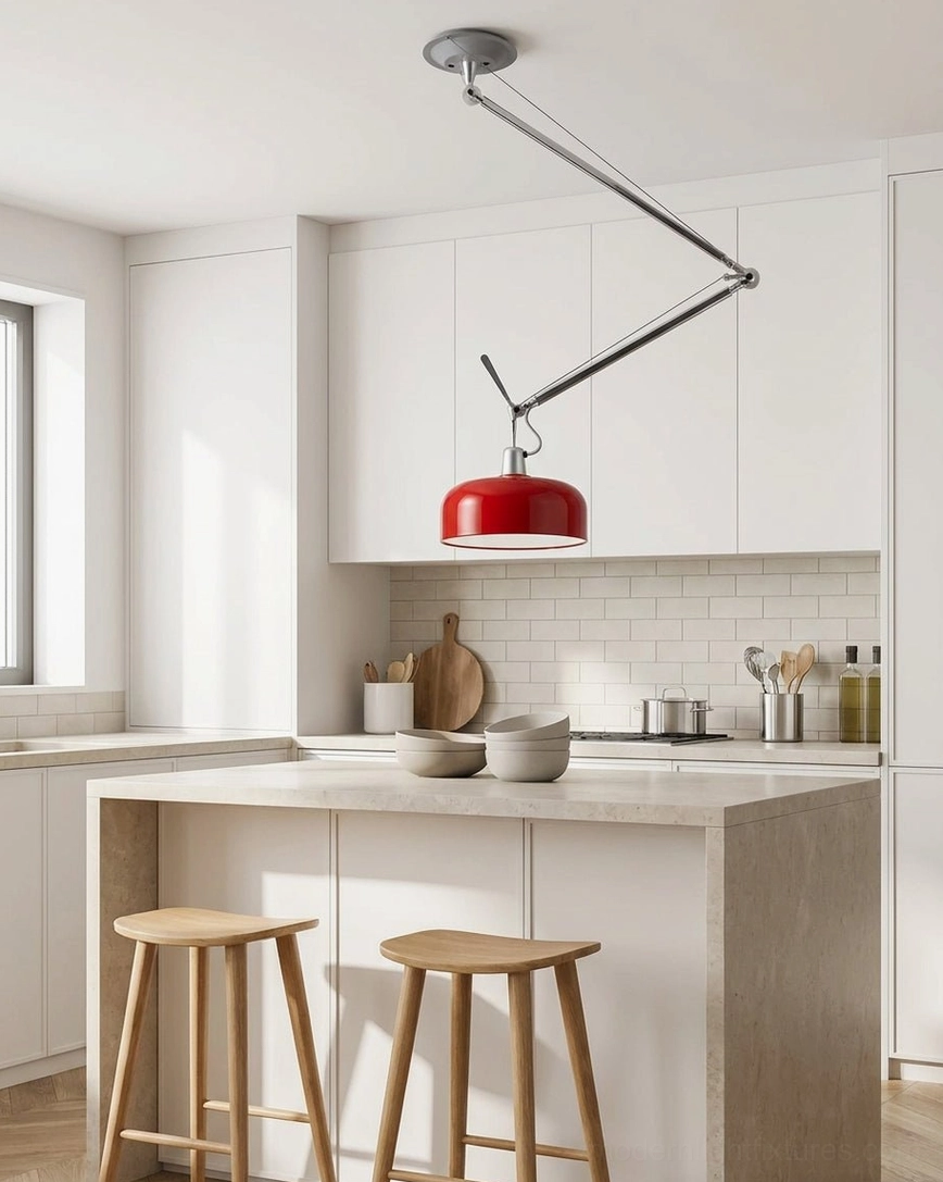 Red swing-arm pendant light above modern white kitchen island