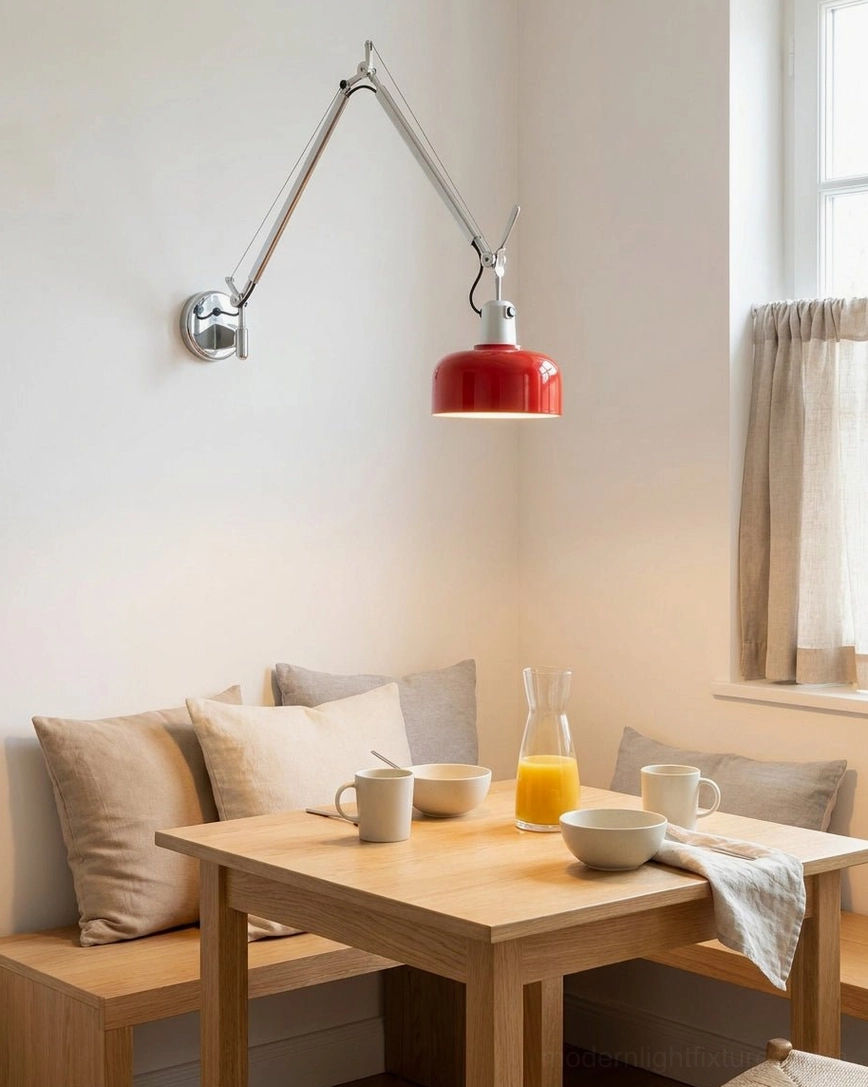 Swing arm wall sconce mounted above small wooden dining table in home dining nook, adjustable task light position