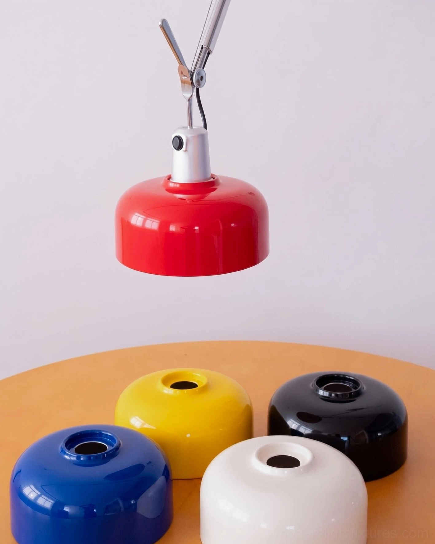 Overhead flat lay display of five Rosso swing arm shade color options: lemon yellow, black, cobalt blue, vermillion red, cream