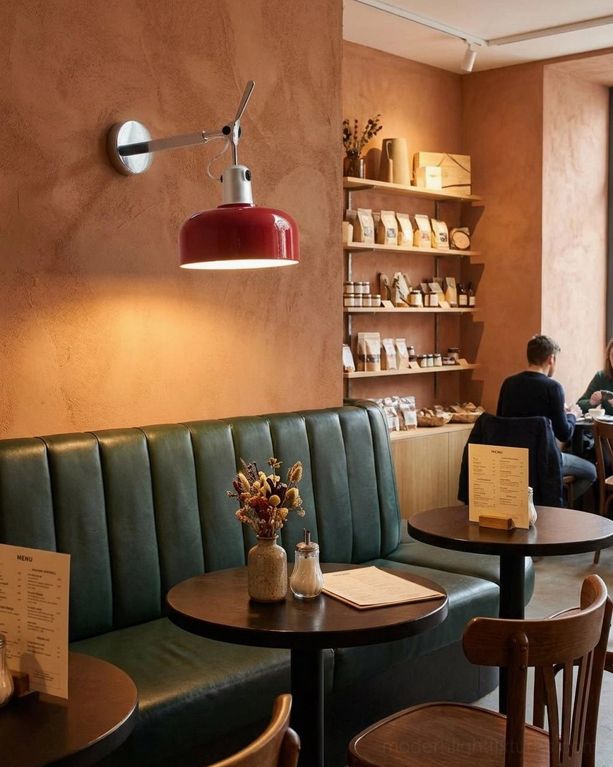Red Rosso wall sconce mounted in modern cafe bistro interior with warm ambient lighting on terracotta accent wall