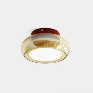 Rotan cognac glass ceiling light with cherry red accent band, front-view studio shot showing warm amber glass and burgundy base detail