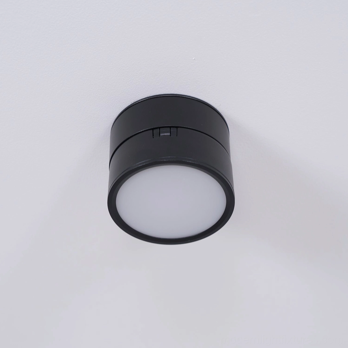 Rotatable ceiling fixture in modern minimalist space showing how compact design disappears against white ceiling