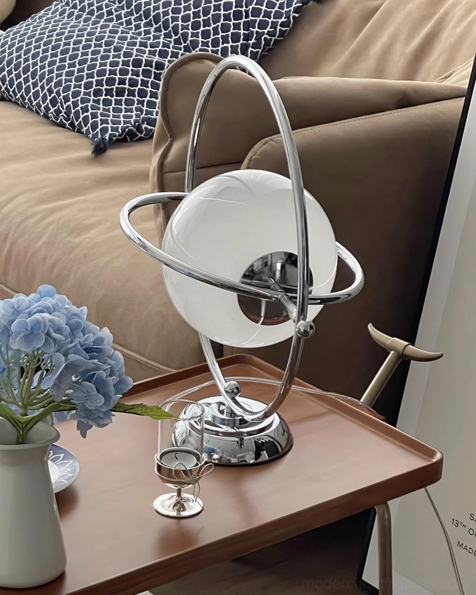 Contemporary chrome planet table lamp in living room beside sofa with wooden side table