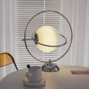 Contemporary planet desk lamp in home setting with warm lighting and window blinds background