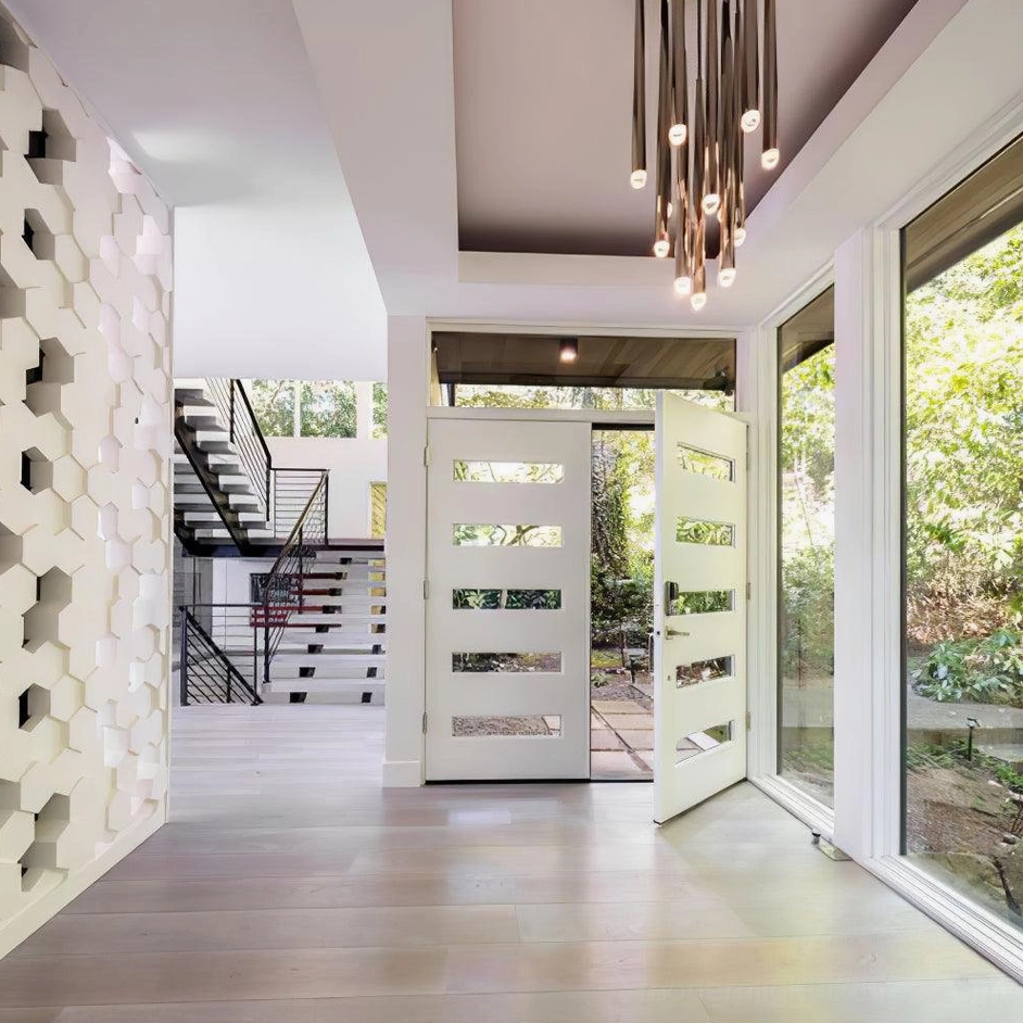 Multi-head cluster chandelier suspended in modern entryway with double doors
