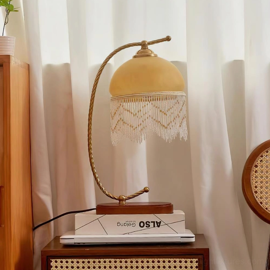 Roussillon Tassel Table Lamp with gold and yellow frosted glass shade on vintage side table with stacked books decorative setting