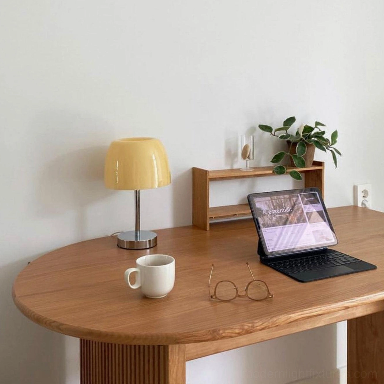 Roxboro amber glass table lamp on wood desk workspace with laptop coffee and plants