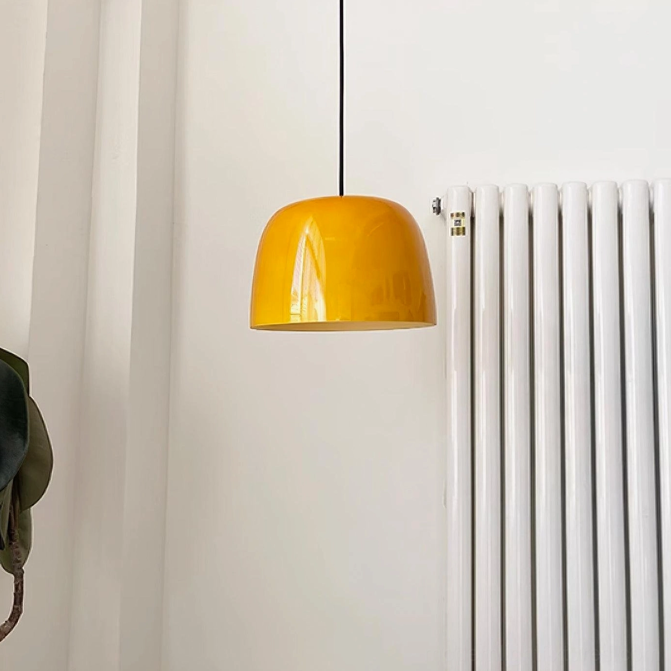 Roxboro modern pendant lamp installed beside white radiator in minimalist home interior setting