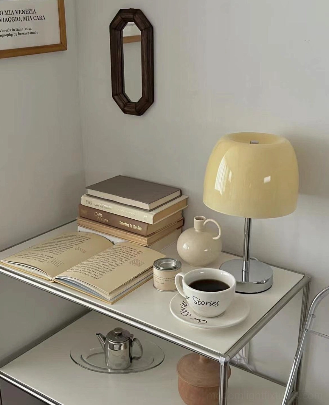 Roxboro cream yellow glass table lamp on side table with books and coffee accessories