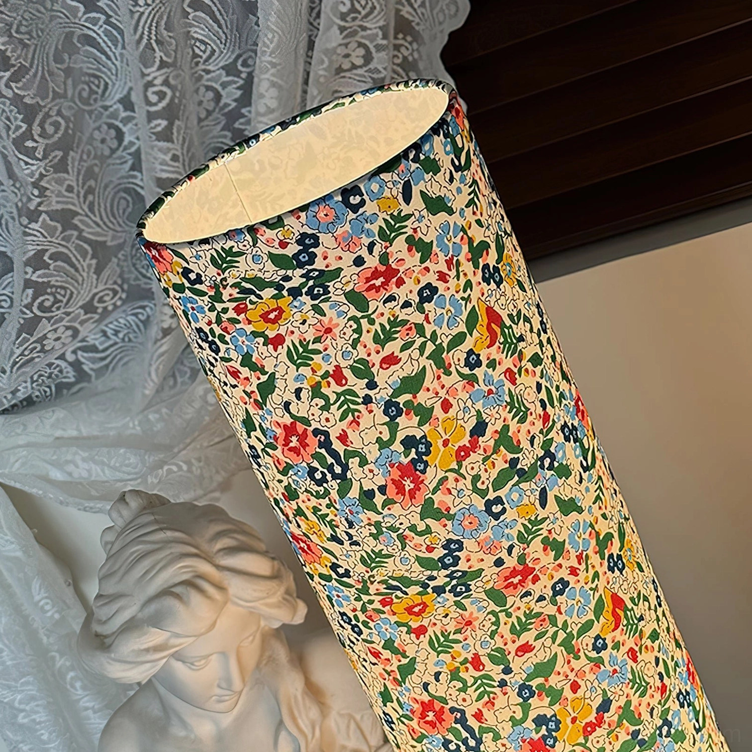 Roya Floral Floor Lamp with vibrant fabric shade and sturdy wooden tripod in soft natural lighting environment