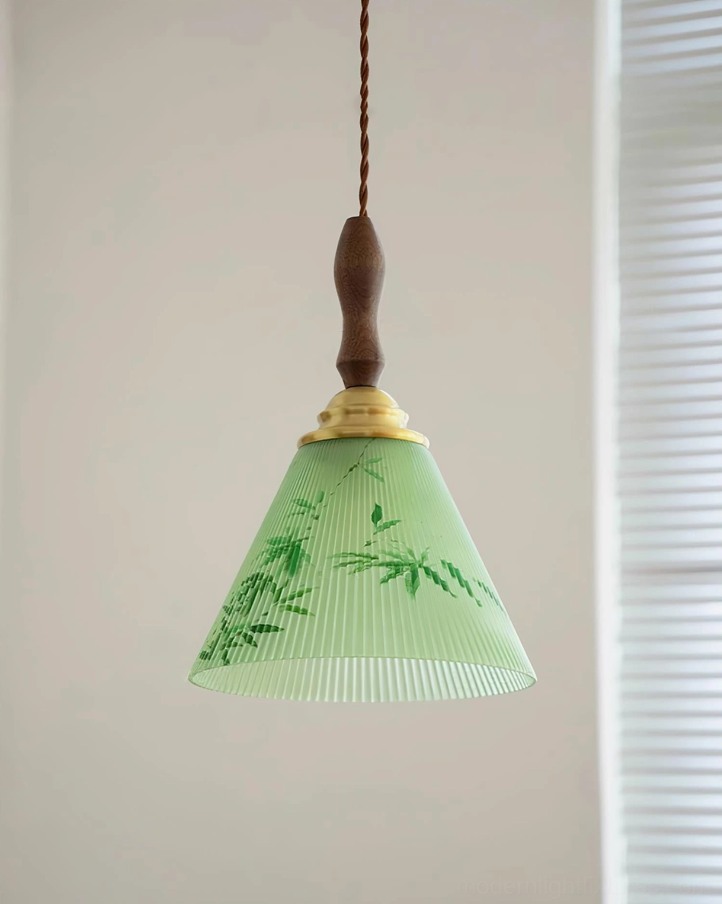 Botanical pendant light installed near louvered window, showing brass and wood connecting hardware details