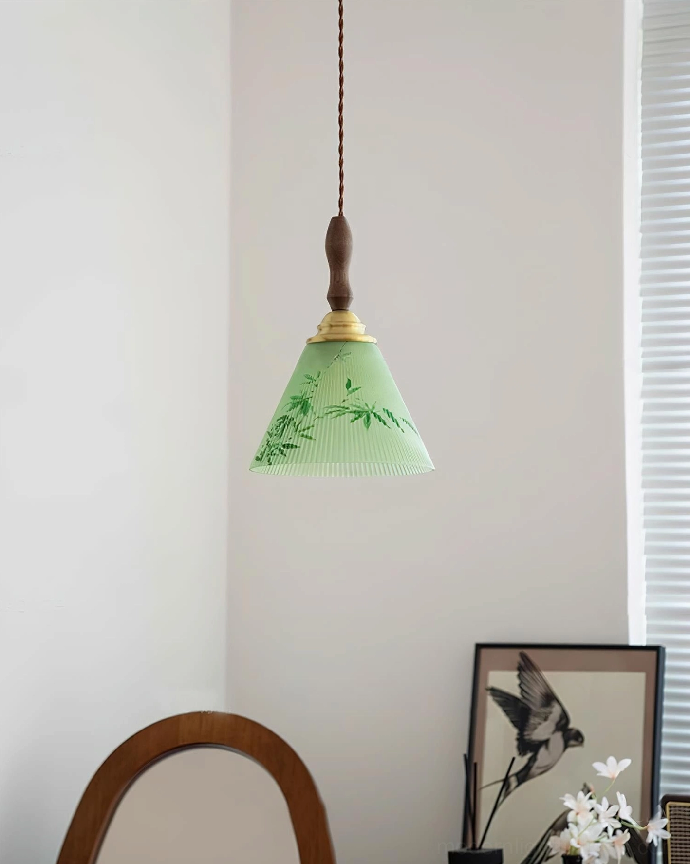 Side view of botanical pendant light against fully closed louvered window showing complete fixture design