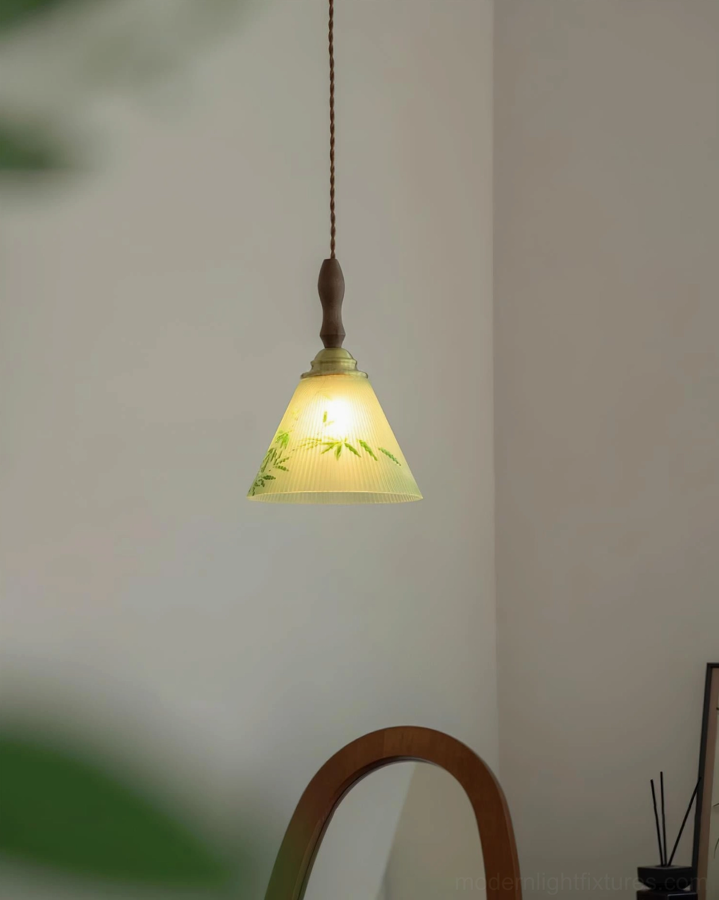Royale Botanical Pendant Light suspended indoors with wooden and brass top fixtures and twisted brown cord