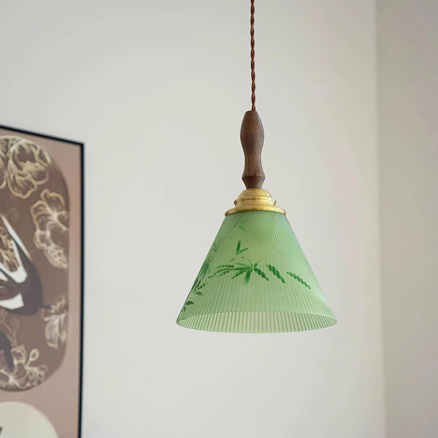 Botanical pendant light with green ribbed shade and bamboo patterns suspended indoors near framed wall artwork