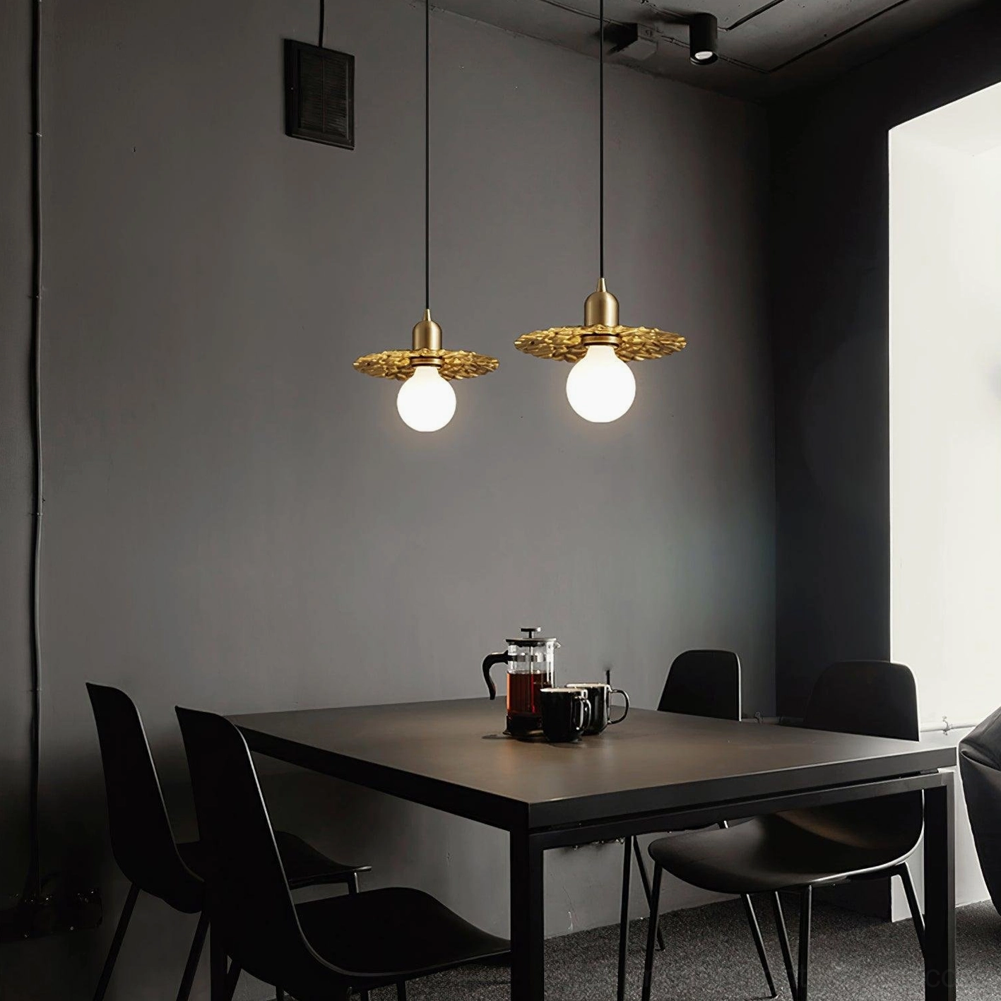 Multiple matching brass petal pendant lights suspended over formal dining table in luxury interior