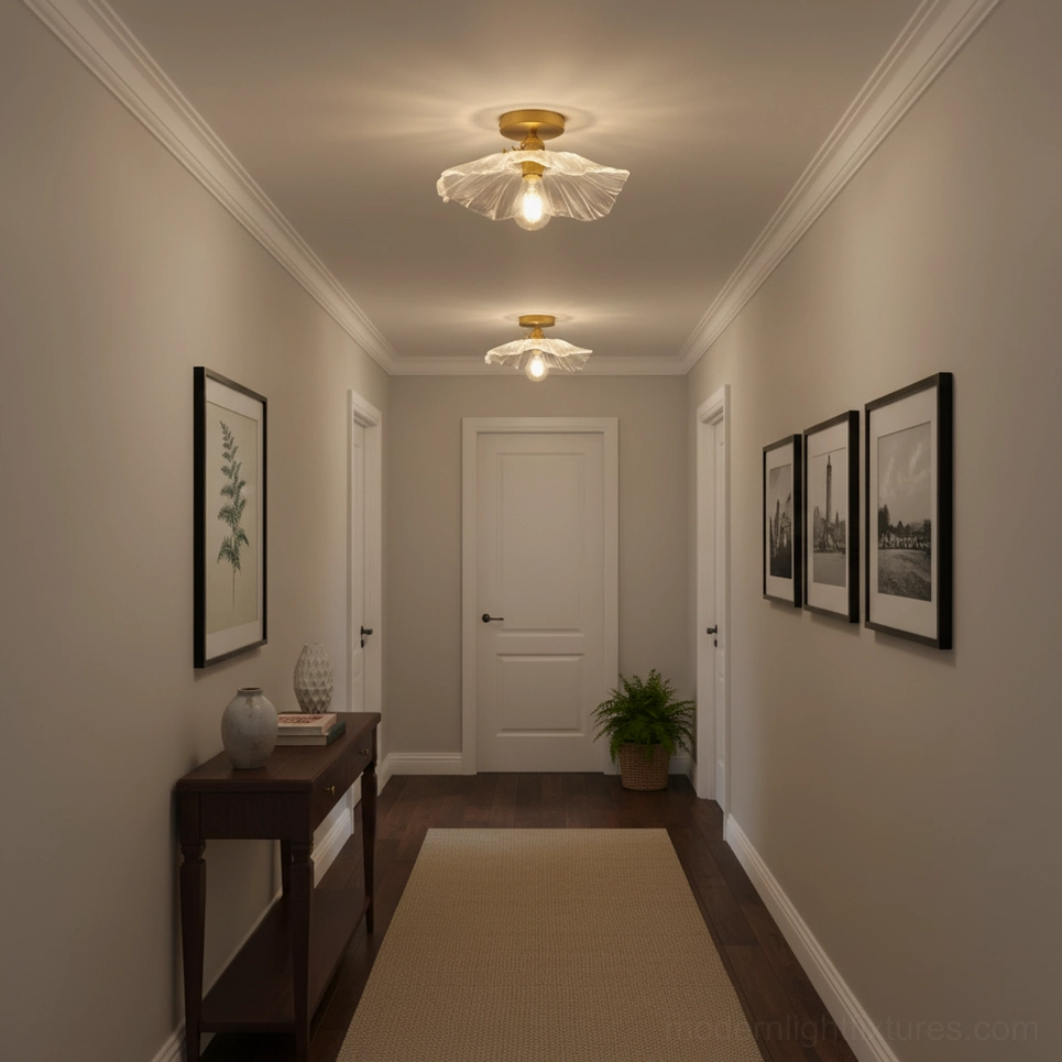 Long hallway perspective showing two vintage ruffled glass ceiling fixtures coordinating with wall art and console tables