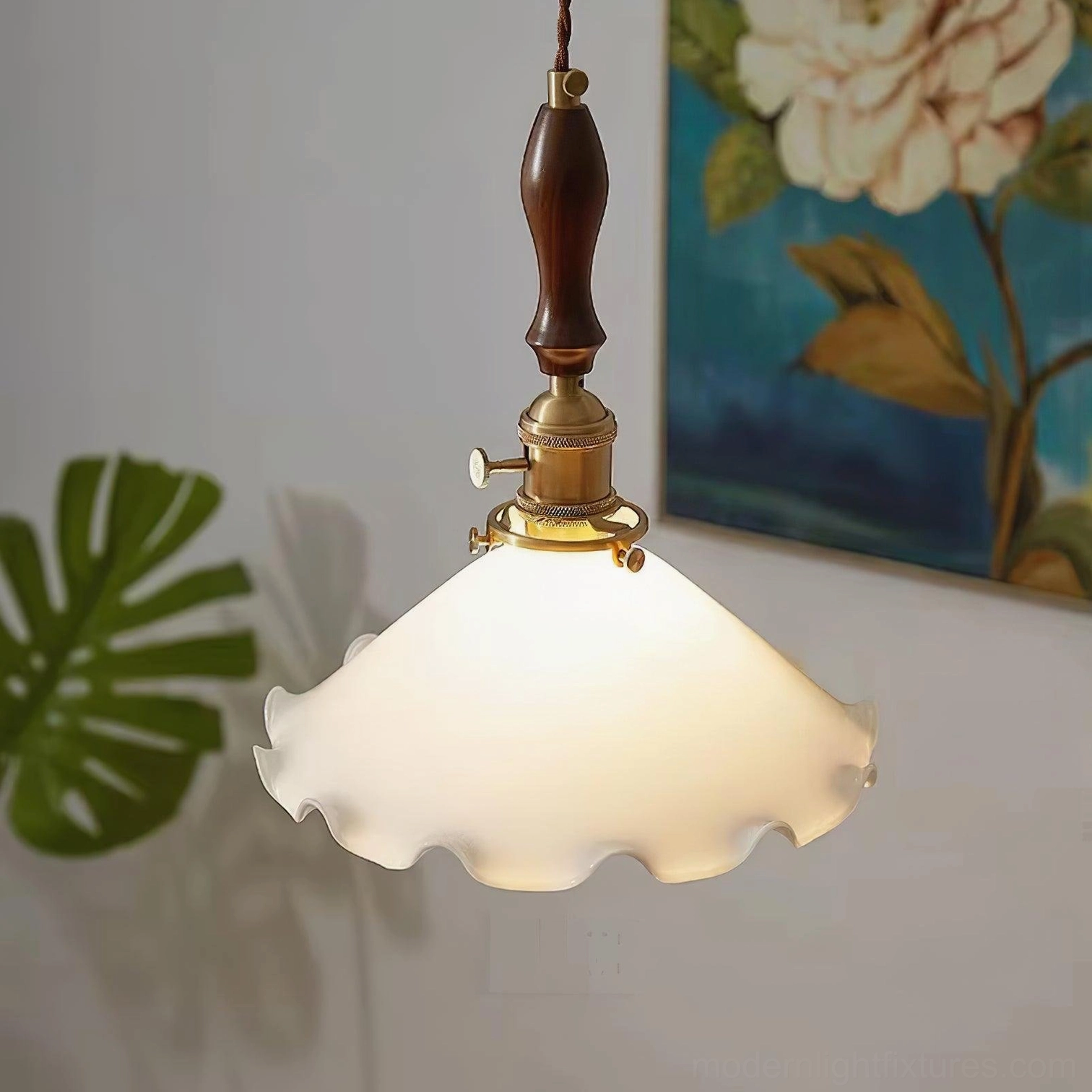 Ruffled glass pendant light with brass accents in residential interior, oblique view with wall art