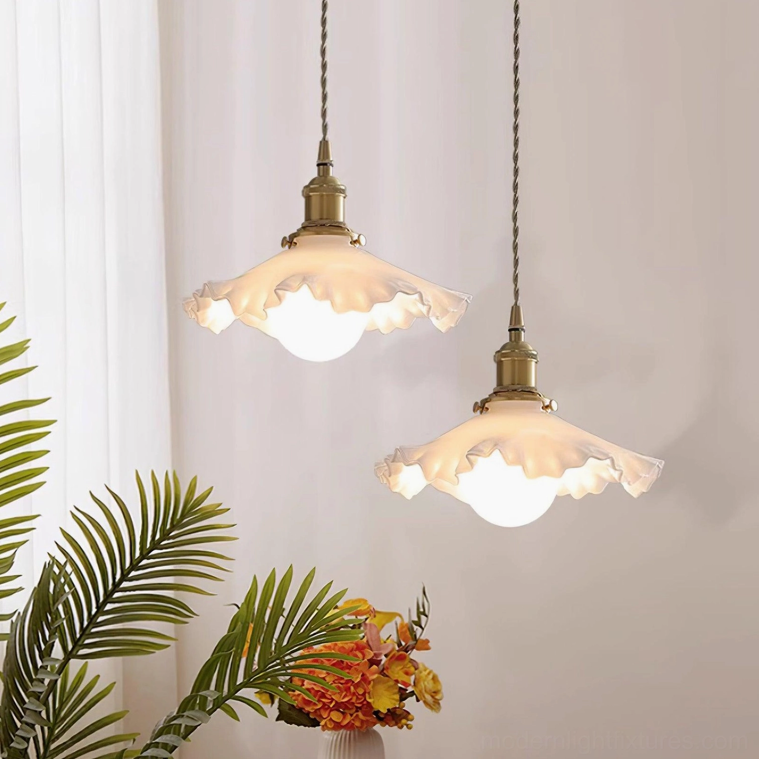 Ruffled pendant light fixture with warm brass components and white frosted shade, product styling view