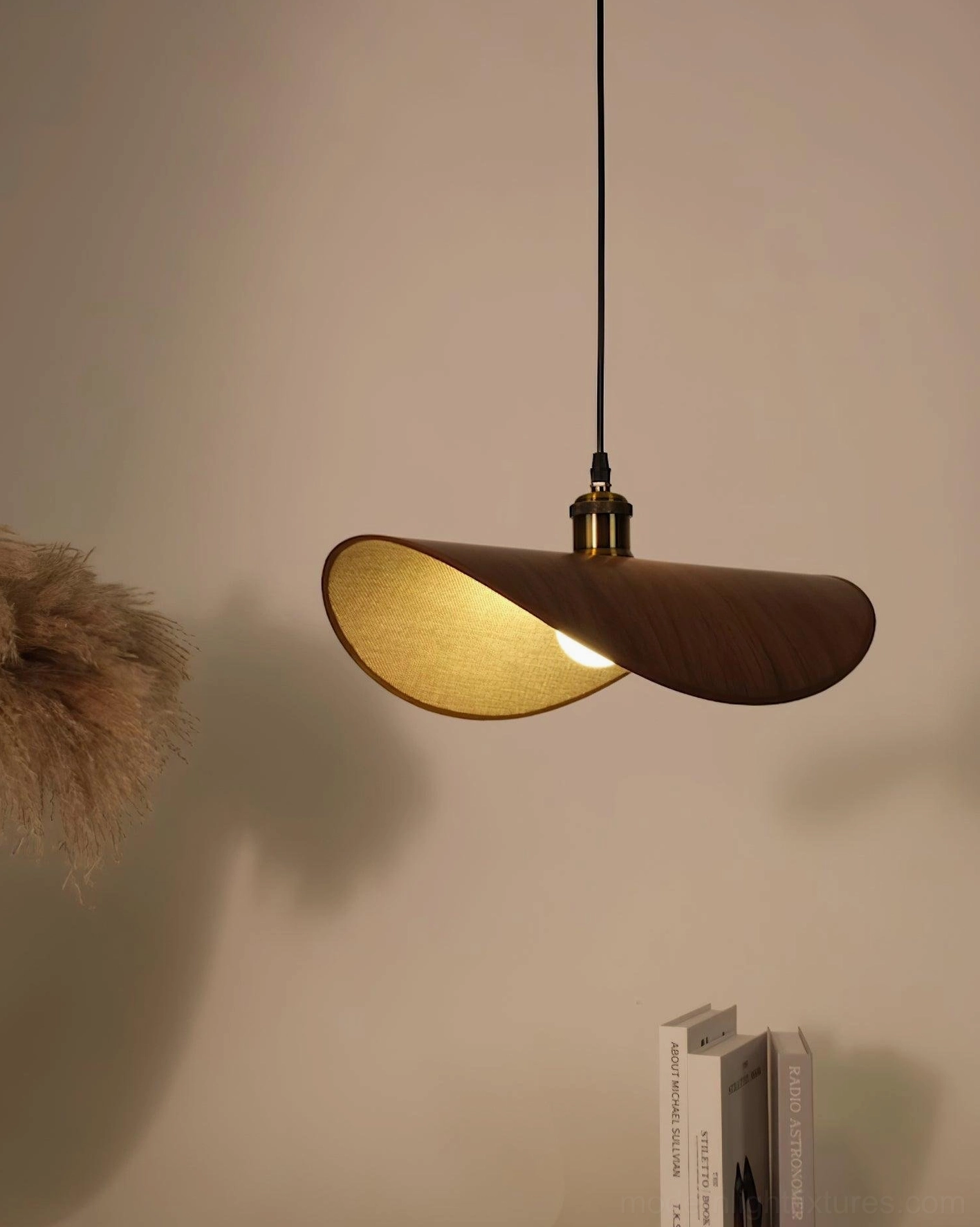 Single wabi-sabi pendant lamp with dark wood shade and warm glowing light, side eye-level view with minimalist decor