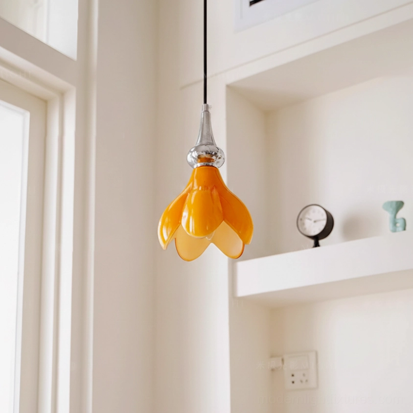 Saffron flower pendant light detail showing organic petal shade sculpting and warm orange glass color illumination effect