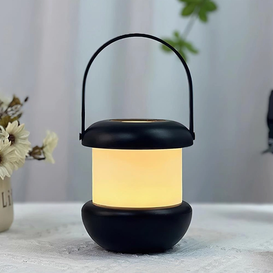 Matte black Sarina LED table lamp with warm illumination and frosted acrylic diffuser on tabletop setting