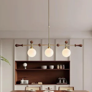 Satilla 3-head linear pendant light installed above wooden dining table with warm neutral home decor