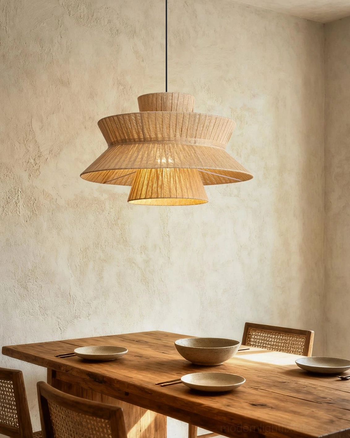 Satori tiered woven jute pendant light above dining table with place settings and tableware
