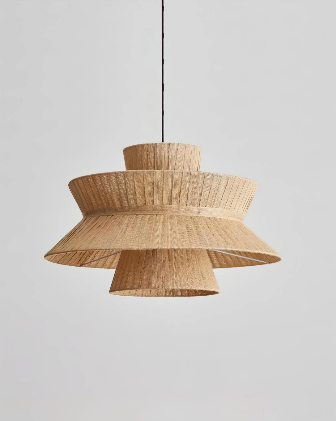 Side profile of Satori tiered pendant light displaying beige jute cloth layered shade construction