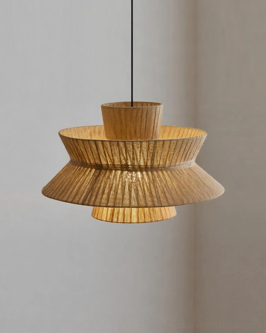 Close-up detail of Satori tiered pendant illuminated showing warm interior glow and jute weave texture